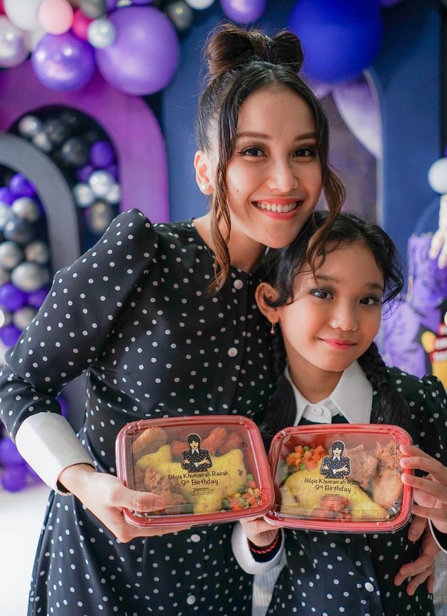 Berbeda dengan Bilqis, Ayu tampak menata rambutnya ke atas dan dibentuk menyerupai pita. Ia kemudian menyisakan poni pada bagian kiri dan kanan rambutnya. Sementara Bilqis dikepang dua seperti penampilan khas Wednesday Addams. Foto: Instagram/@ayutingting92