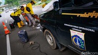 Petugas Bina Marga DKI Jakarta menambal jalan bolong di kolong Semanggi, Jakarta, Senin (2/1/2023) pukul 15.30 WIB.