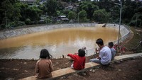 Sejumlah anak bermain dan melihat-lihat di pinggiran Kolam Retensi Cisanggarung, Sindanglaya, Bandung, Jawa Barat, Senin (2/1/2023).  