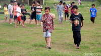 Mereka mengadu ketangkasan memainkan lato-lato dengan melintasi lapangan terbuka.