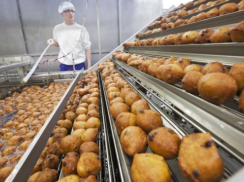 A worker oversees the production of traditional Dutch food known locally as 'oliebollen' at a bakery in Beverwijk, on November 7, 2011. The bakery produces 13.000 oliebollen per hour. 'Oliebol'  (literally tranlated as 'oil balls') are traditionally eaten on New Year's Eve and at funfairs. AFP PHOTO / ANP / KOEN SUYK   ***Netherlands out - Belgium out*** (Photo credit should read KOEN SUYK SUYK/AFP via Getty Images)