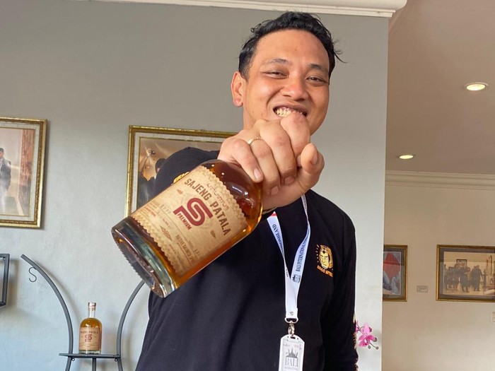 Owner Sajeng Patala, I Komang Sedana Putra menunjukkan produk arak Bali miliknya. (foto: istimewa)