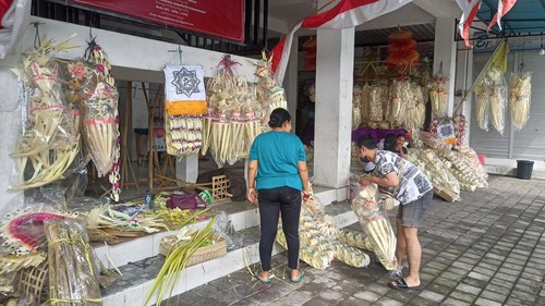 Penjual hiasan penjor di Jalan Teuku Umar, Karangasem, Bali, saat melayani pembeli, Senin (2/1/2023)
