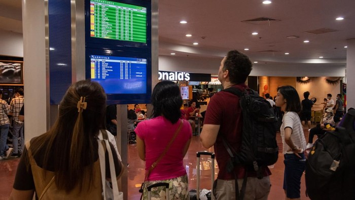 Passengers wait for information about their flights at terminal 3 of Ninoy Aquino International Airport in Pasay, Metro Manila on January 1, 2023. - Thousands of travellers were stranded at Philippine airports on January 1 after a 