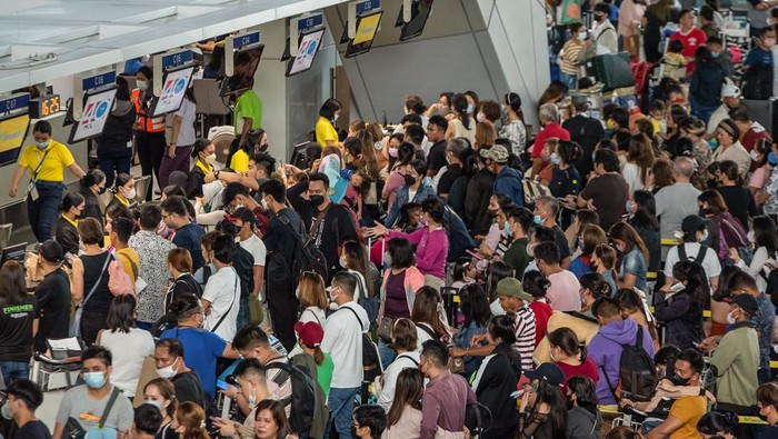 Ribuan Pelancong Terdampar di Bandara Filipina Gegara Listrik Padam Passengers wait for information about their flights at terminal 3 of Ninoy Aquino International Airport in Pasay, Metro Manila on January 1, 2023. - Thousands of travellers were stranded at Philippine airports on January 1 after a