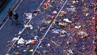 Orang-orang berjalan di sepanjang jalan yang dipenuhi sampah di Times Square, New York, Amerika Serikat, Minggu (1/1/2023).(Gary Hershorn/Getty Images)