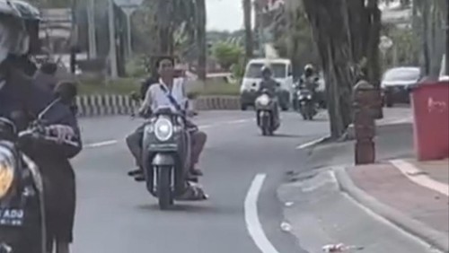 Tangkapan layar video viral pemotor berboncengan menyeret bangkai anjing dan dibuang ke sungai. (I Wayan Sui Suadnyana/detikBali)