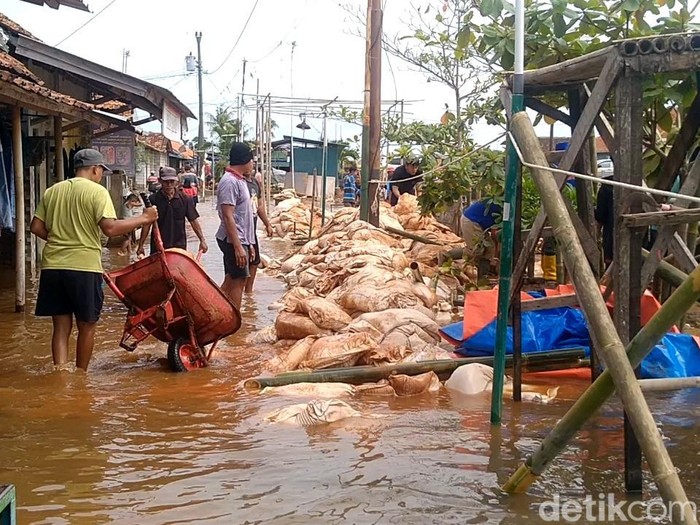 Kondisi tanggul Sungai Meduri, Kota Pekalongan, yang jebol sepanjang 50 meter. Warga bergotong royong menambal tanggul itu secara darurat, Senin (2/1/2023) siang.