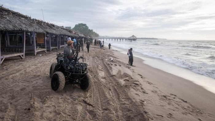 Wisatawan berswafoto di Pantai Anyer, Kabupaten Serang, Banten, Minggu (1/1/2023). Pengelola pantai setempat menuturkan, objek wisata di pesisir pantai tersebut pada libur Tahun Baru 2023 sepi pengunjung akibat dampak dari gelombang tinggi yang terjadi sejak beberapa hari terakhir di perairan Selat Sunda.