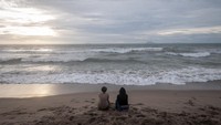 Wisatawan menikmati suasana di Pantai Anyer, Kabupaten Serang, Banten, Minggu (01/01/2023).