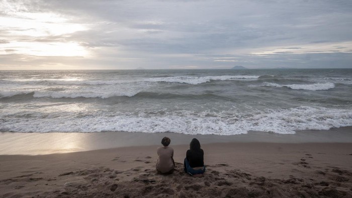 Wisatawan berswafoto di Pantai Anyer, Kabupaten Serang, Banten, Minggu (1/1/2023). Pengelola pantai setempat menuturkan, objek wisata di pesisir pantai tersebut pada libur Tahun Baru 2023 sepi pengunjung akibat dampak dari gelombang tinggi yang terjadi sejak beberapa hari terakhir di perairan Selat Sunda.