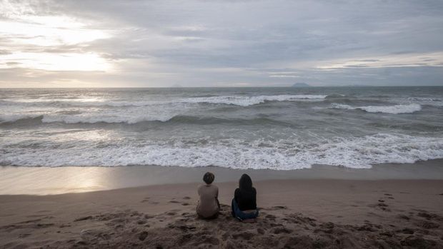 Wisatawan berswafoto di Pantai Anyer, Kabupaten Serang, Banten, Minggu (1/1/2023). Pengelola pantai setempat menuturkan, objek wisata di pesisir pantai tersebut pada libur Tahun Baru 2023 sepi pengunjung akibat dampak dari gelombang tinggi yang terjadi sejak beberapa hari terakhir di perairan Selat Sunda.