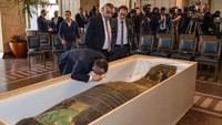 Mostafa Waziri, Kepala Dewan Tertinggi Kepurbakalaan Mesir memeriksa tutup sarkofagus menggunakan kaca pembesar. Sarkofagus ini sangat tebal, sehingga penjarah hanya mencuri tutup sarkofagus saja tanpa bagian bawah petinya, kata Waziri. (Foto: AFP via Getty Images/)