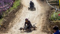 Peserta berlomba dengan mobil kayu dalam laga Formula Hmong di Desa Mae Rim, Chiang Mai, Thailand, Senin (2/1/2023).