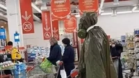 Orang ini juga takut terpapar virus. Karenanya ia menutup dirinya menggunakan jas ujan dengan masker saat berbelanja di pusat perbelanjaan. Foto: Instagram/Twitter