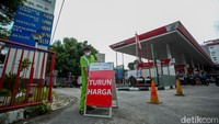Petugas juga memasang plang Turun Harga di depan SPBU.  