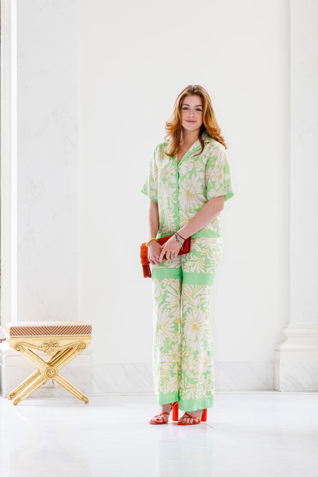Putri Alexia of Netherlands mengenakan setelan resort berupa kemeja dan celana longgar saat sesi foto bersama keluarga. Untuk memberi kesan stylish, dia mengenakan high heels dan clutch warna merah menyala. Foto: Getty Images