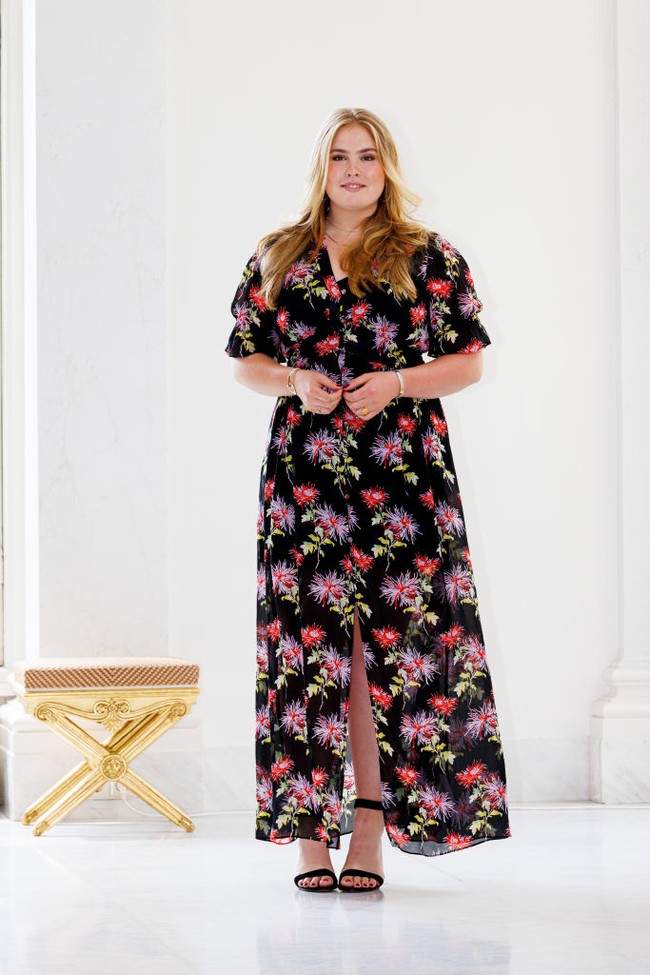 Putri Amalia of Netherlands tampil feminin dengan gaun panjang hitam motif bunga. Gaun berbelahan paha di bagian tengah itu dipadukan dengan hihg heels hitam yang senada dengan gaun. Foto: Getty Images
