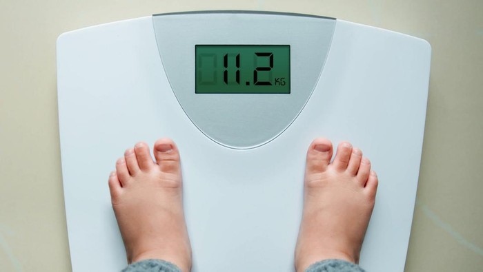 Healthy Weight Gain for Baby or Children Concept, A 2 Years Old Kid Standing on Weight Scales, Top View