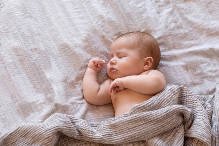Close-up of sleeping baby on the bed with copy space. New family and baby sleep concept