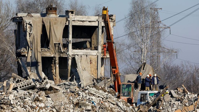 Workers remove debris of a destroyed building purported to be a vocational college used as temporary accommodation for Russian soldiers, 63 of whom were killed in a Ukrainian missile strike as stated the previous day by Russias Defence Ministry, in the course of Russia-Ukraine conflict in Makiivka (Makeyevka), Russian-controlled Ukraine, January 3, 2023. REUTERS/Alexander Ermochenko