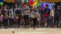 Seorang peserta melepaskan gasing kayunya saat perlombaan gasing di Chiang Mai, Thailand, Senin (2/1/2023).  
