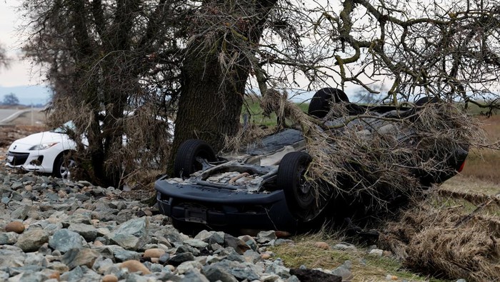 Mobil-mobil di California Saling Tumpuk Terseret Badai Cars are piled up next to a wheelchair submerged in the water after rainstorms caused flooding in Sacramento County, in Wilton, California, U.S. January 2, 2023. REUTERS/Fred Greaves