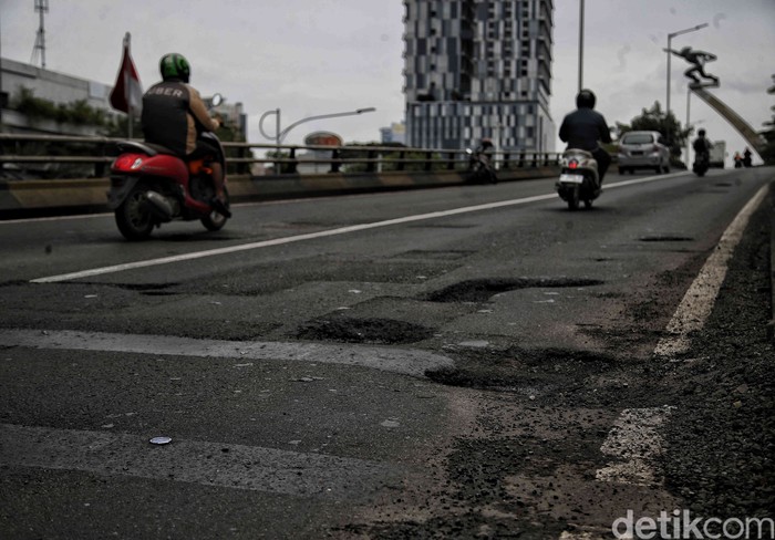 Pengendara diimbau waspada terhadap banyaknya lubang di jembatan layang Pancoran, Jakarta, Selasa (03/01/2023). Jalan berlubang ini bisa menyebabkan masyarakat celaka.