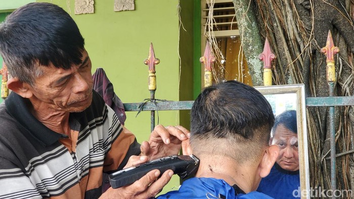 Pangkas rambut di bawah beringin Alun-alun Utara Jogja. Foto diambil Minggu (1/3/2023).