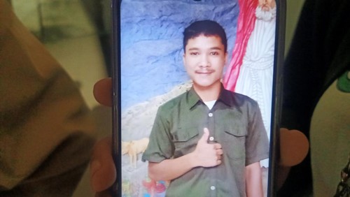 Bibi korban Andika menunjukkan foto mendiang yang tersimpan di HP.