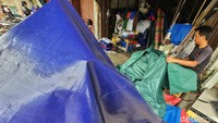Meski tidak menyebut angka pasti, para pekerja menyatakan penjualan terpal plastik meningkat saat musim hujan.