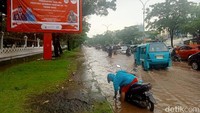 Sejumlah kendaraan yang melintasi genangan air di depan Kantor Gubernur Sulsel Jalan Urip Sumoharjo tampak memperlambat laju kendaraan. (Foto: Ibrahim Rewa/detikSulsel)