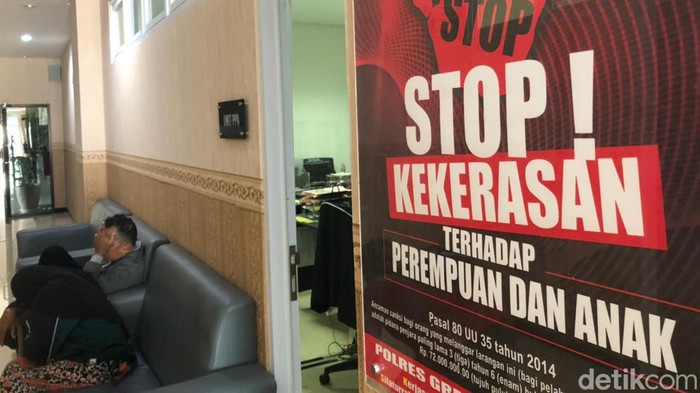 Ayah tiri (jaket abu-abu) dan ibu korban saat berada di Polres Gresik.