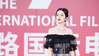 Dia tampak cantik mengenakan rok motif selutut dan atasan hitam yang memperlihatkan pundaknya.  Foto: VCG via Getty Images/VCG