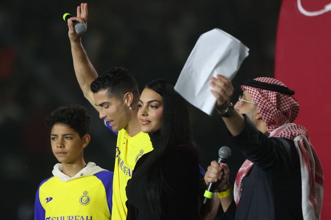 Cristiano Ronaldo resmi dikenalkan sebagai pemain baru klub sepakbola Arab Al Nassr dalam sebuah perhelatan meriah yang digelar di Mrsool Park Stadium, Riyadh, pada Selasa (3/1/2023). Tak sendiri, ia datang bersama sang kekasih, Georgina Rodríguez, dan keempat anak mereka. (Foto: AFP via Getty Images/FAYEZ NURELDINE)