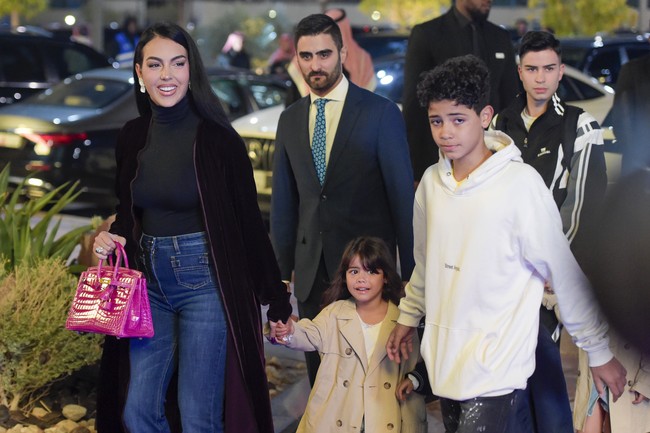 Tas Hermes Birkin berwarna pink juga tak absen dari penampilan Georgina Rodríguez saat tiba di lokasi acara. Sebelumnya dalam perjalanan menuju Riyadh dengan jet pribadi, ia berpose dengan tas Hermes yang berbeda. (Foto: Getty Images/Khalid Alhaj/MB Media)