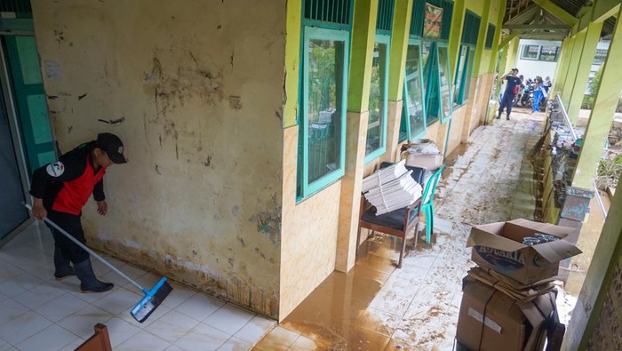 GOTONG ROYONG BERSIH SEKOLAH TERDAMPAK BANJIR Petugas pemadam kebakaran membersihkan lumpur sisa banjir di SMP N 9, Kabupaten Batang, Jawa Tengah, Rabu (4/1/2023). Sekolah melibatkan siswa dan pemadam kebakaran untuk membersihkan lumpur sisa banjir akibat hujan deras yang terjadi pada Sabtu (31/12/2022) dan Senin (2/1/2023) itu. ANTARA FOTO/Harviyan Perdana Putra/rwa.