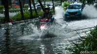 Para pengendara tetap nekat melintas meski jalanan tergenang air.