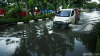 Pengendara mobil nekat menerobos genangan di Jalan Sultan Iskandar Muda, Kebayoran Lama.