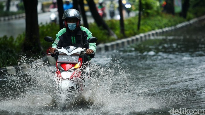 Pengendara nekat melawan air di jalan Sultan Iskandar Muda, Kebayoran Lama, Jakarta, Rabu (4/1/2023).
