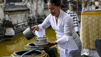 Salah satu umat Hindu yang merayakan Galungan mengaku senang sekali bisa turut merayakan hari raya Galungan. Sebab, pasca PPKM dicabut dan angka pandemi COVID-19, suasana dan ritme sembahyang berangsur normal kembali. (Sonny Tumbelaka/AFP/Getty Images)  