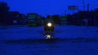 Sejumlah kendaraan menerobos jalan yang tergenang banjir di jalan nasional jalur Pantura (Pantai Utara) Desa Jati Wetan, Kudus, Jawa Tengah, Selasa (3/1/2023). 