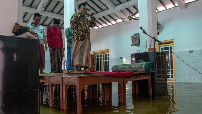 Masjid di Demak Terendam Banjir, Warga Salat di Atas Meja Sejumlah warga melaksankan Shalat Asar berjamaah di atas meja yang diletakkan di lantai Masjid Jami Al Muttaqin yang terendam banjir di Desa Prampelan, Kecamatan Sayung, Kabupaten Demak, Jawa Tengah, Selasa, (3/1/2023). Warga setempat memanfaatkan meja untuk saf shalat berkapasitas terbatas karena banjir merendam lantai masjid tersebut dengan ketinggian bervariasi antara 10-30 cm akibat intensitas hujan tinggi sejak Sabtu (31/12/2022) dini hari. ANTARA FOTO/Aji Styawan/foc.
