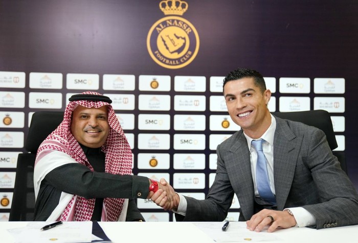 RIYADH, SAUDI ARABIA - JANUARY 03: (----EDITORIAL USE ONLY â MANDATORY CREDIT - AL NASSR FOOTBALL CLUB / HANDOUT - NO MARKETING NO ADVERTISING CAMPAIGNS - DISTRIBUTED AS A SERVICE TO CLIENTS----)  Portuguese superstar, Ronaldo shakes hands with President of Al Nassr FC. Musalli Al-Muammar after signing an agreement at Mrsool Park Stadium, in Riyadh, Saudi Arabia on January 03, 2023. (Photo by AL Nassr Club of Saudi Arabia/Anadolu Agency via Getty Images)