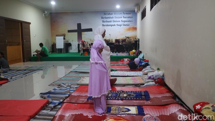 Pengungsi banjir di Kudus menjalankan salat di aula gereja yang menjadi tempat pengungsian, Rabu (4/1/2023).