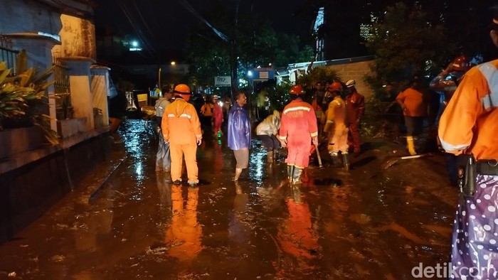 Petugas gabungan dan relawan sedang membersihkan material sisa banjir di daerah Kaligarang Ungaran