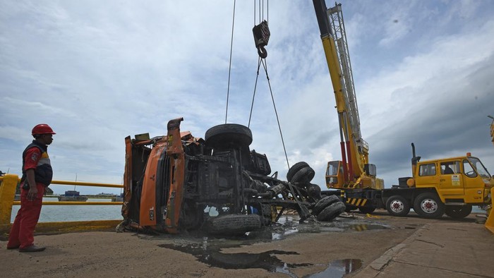 Petugas mengarahkan penurunan truk yang baru diangkat dari laut di Dermaga V Pelabuhan Merak, Banten, Rabu (4/1/2023). Tim Penyelematan Bawah Air Koarmada I TNI AL dibantu puluhan personel Pangkalan TNI AL (Lanal) Banten berhasil mengangkat bangkai truk pengangkut semen yang jatuh ke laut akibat kecelakaan pada Rabu (28/12/2022) lalu. ANTARA FOTO/Asep Fathulrahman/hp.