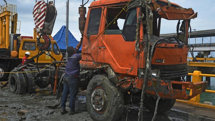 Potret Evakuasi Truk Semen yang Tercebur di Pelabuhan Merak Petugas mengarahkan penurunan truk yang baru diangkat dari laut di Dermaga V Pelabuhan Merak, Banten, Rabu (4/1/2023). Tim Penyelematan Bawah Air Koarmada I TNI AL dibantu puluhan personel Pangkalan TNI AL (Lanal) Banten berhasil mengangkat bangkai truk pengangkut semen yang jatuh ke laut akibat kecelakaan pada Rabu (28/12/2022) lalu. ANTARA FOTO/Asep Fathulrahman/hp.