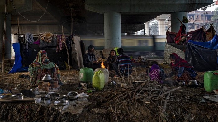 A homeless woman sits by the entrance to the a dilapidated shelter for homeless people in New Delhi, Dec. 30, 2022. The piercing chill is an ordeal for the city’s homeless, with New Delhi Sunday recording the minimum temperature of 5.5 degrees Celsius (41.9 Fahrenheit). New Delhi's 195 homeless shelters can accommodate only about 19,000 people, leaving tens of thousands struggling to keep warm. (AP Photo/Altaf Qadri)