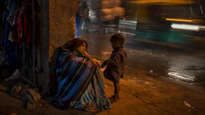 A homeless woman sits by the entrance to the a dilapidated shelter for homeless people in New Delhi, Dec. 30, 2022. The piercing chill is an ordeal for the city’s homeless, with New Delhi Sunday recording the minimum temperature of 5.5 degrees Celsius (41.9 Fahrenheit). New Delhi's 195 homeless shelters can accommodate only about 19,000 people, leaving tens of thousands struggling to keep warm. (AP Photo/Altaf Qadri)
